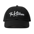 Black cap with 'The Kitchen' text on a white background