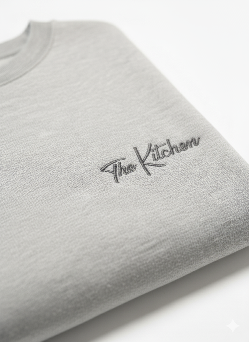 Gray sweatshirt with 'The Kitchen' logo on a white background