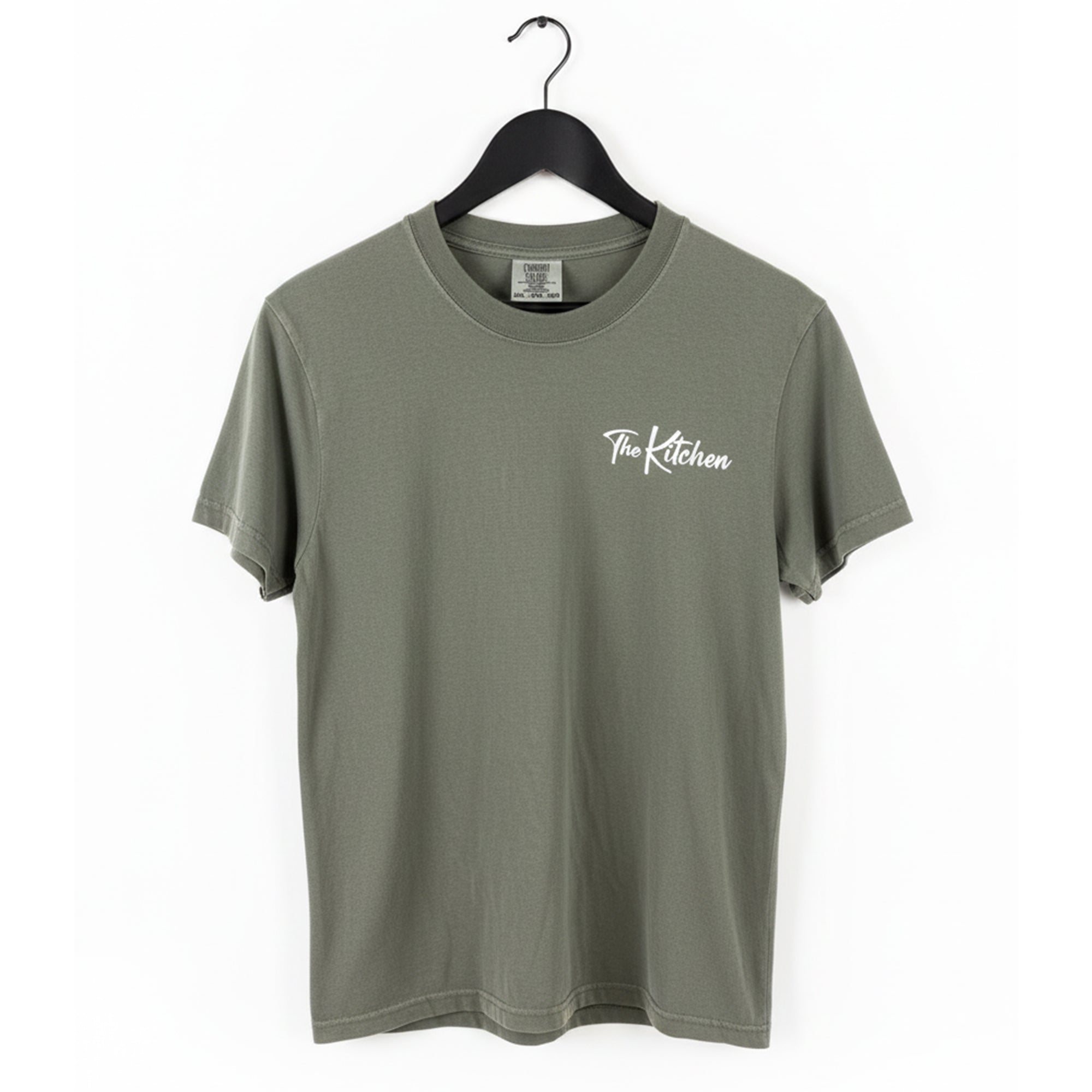 Green t-shirt with 'The Kitchen' text on a hanger against a white background
