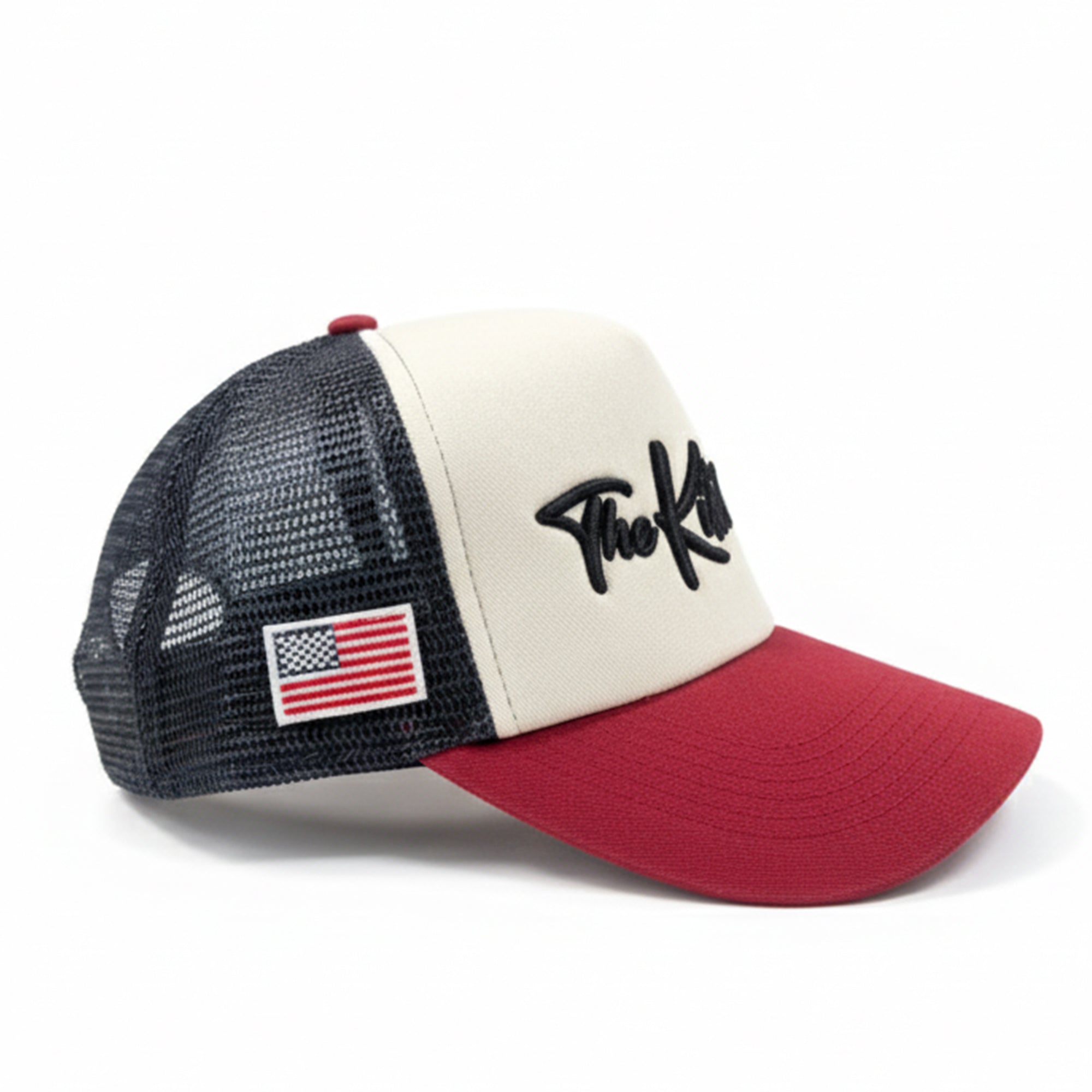 Trucker hat with American flag and 'The Kid' logo on a white background