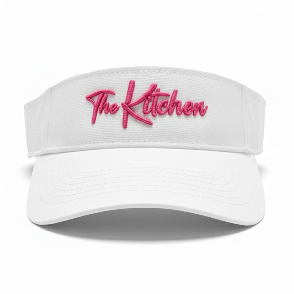 White visor with pink 'The Kitchen' text on a white background